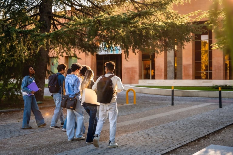 Estudiantes diversos caminando por el campus universitario, representando educación y nuevas oportunidades de aprendizaje